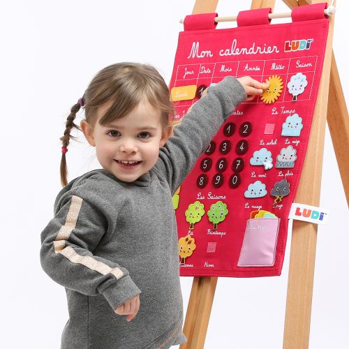 Basic Pink embroidered calendar, 100% cotton, with removable elements in felt. Allows the child to find a way in time, to discover the seasons as well as the climate while having fun!