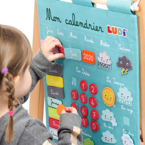 Embroidered calendar, 100% cotton, with removable elements in felt. Allows the child to find a way in time, to discover the seasons as well as the climate while having fun!
