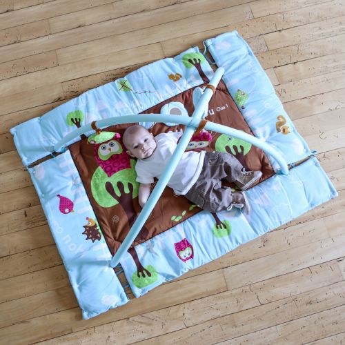 The owl-themed activity play mat with arch. Sides can be drawn up to form a cocoon. There are a variety of colours, fun shapes, and diverse textures to help wake your baby up. 