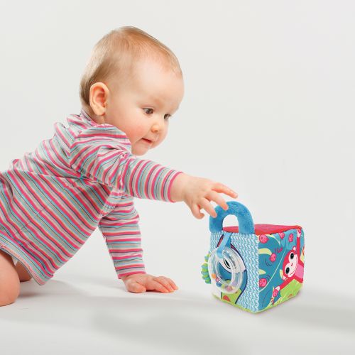 Cube d’éveil en tissu de LUDI. Cube d'activités en tissu doux qui développe le sens du toucher et la coordination des mouvements de bébé tout en s'amusant ! (Poignée, anneau de dentition, rubans, miroir, différentes textures). Pour les enfants dès 3 mois. Référence produit 30038.