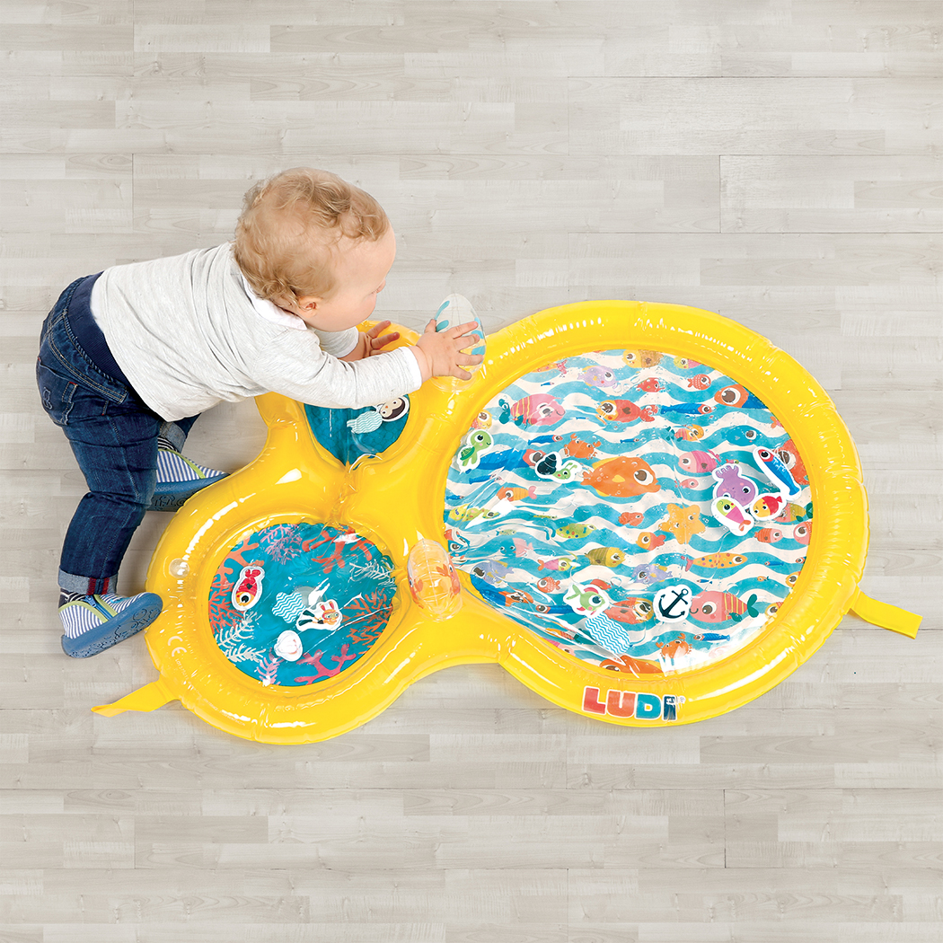 le bébé joue avec le tapis d'eau