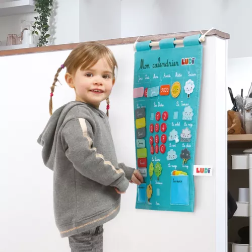 Calendrier pour enfant. Apprendre à lire la date et à s’organiser dans le temps. Notion du temps qui passe : années, mois, jours, saisons, météo. Calendrier en tissu, 100% coton. Étiquettes en feutrine. Référence produit : 2096.