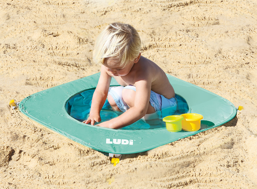 LUDI / 90063 / piscine pop up / 10 mois. facile à installer et à replier, contient un sac de rangement et quatres piquets pour la fixer dans le sable